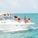 A family of 7 relaxes on the deck of a small boat